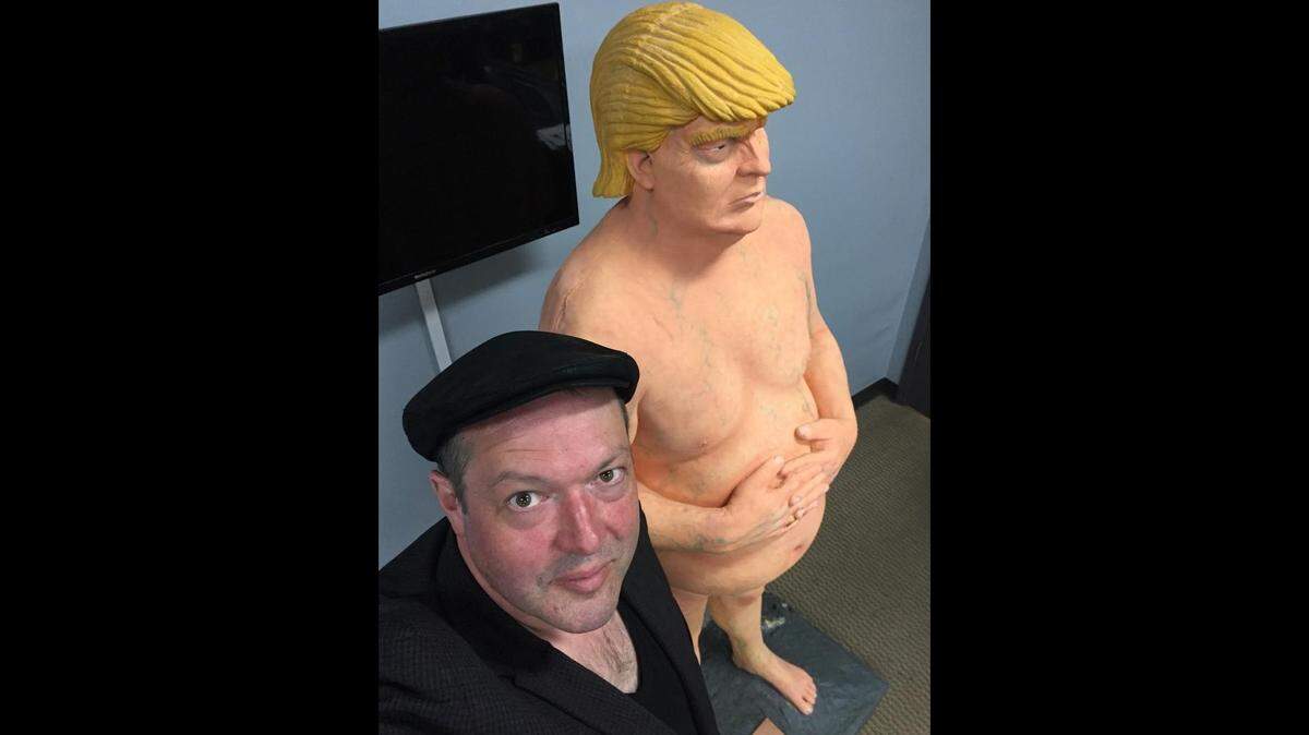 Cartoonist Shannon Wheeler with a statue of President Trump.