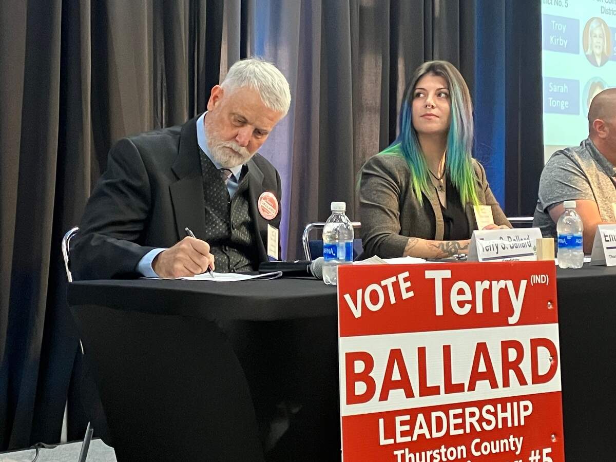 Thurston County District 5 commission candidates Terry Ballard and Emily Clouse listen to the moderator during a Wednesday candidate forum.