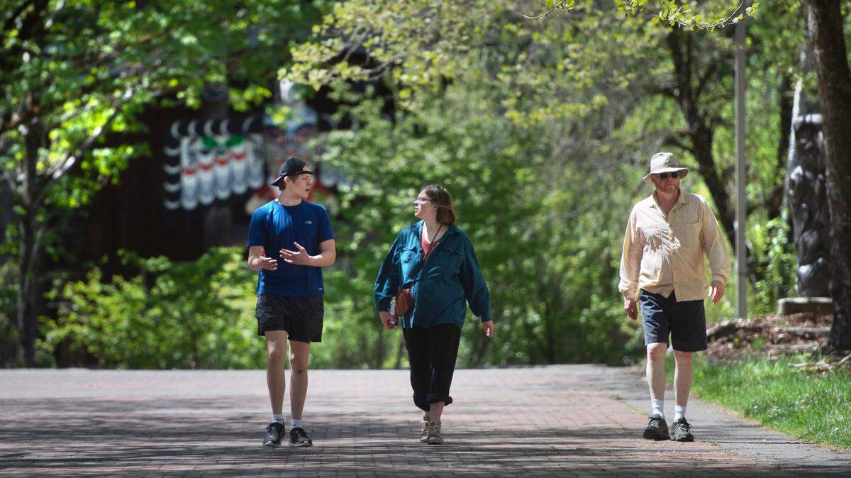 Evergreen student Katherine Mitchell (center) walks with her brother, WSU student Ryan Mitchell, and her dad, Scott Mitchell of Maple Valley, as they visit on the campus of The Evergreen State College in Olympia, Washington, on Friday, May 12, 2023.