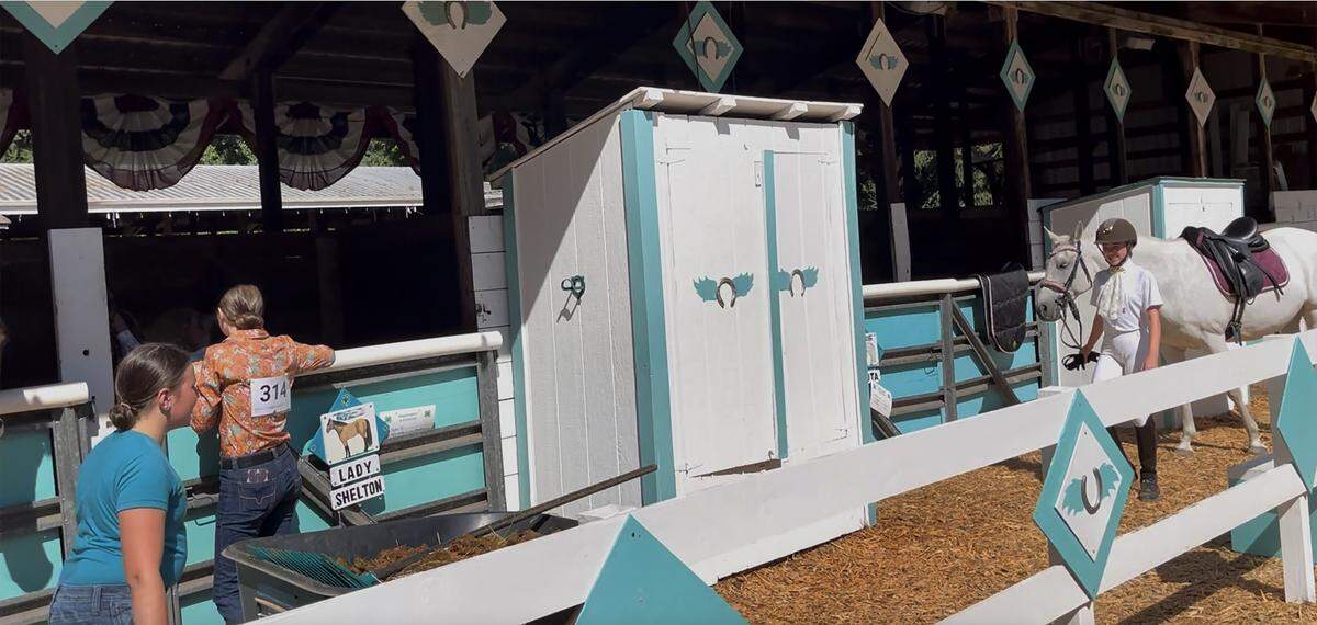 Members of the Flying Hoofs 4-H Club settle into their stable area on move-in day Wednesday morning as staff, animal owners and vendors scurried about in preparation for the Thursday opening of the 2025 Thurston County Fair.