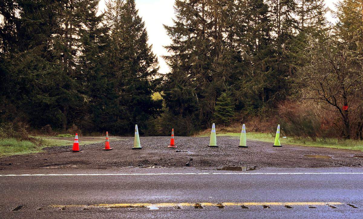 A row of cones block access to one of several unmanned side roads onto Joint Base Lewis-McChord property off of Rainier Road Southeast on Tuesday morning after a Monday night crash of an Army helicopter.