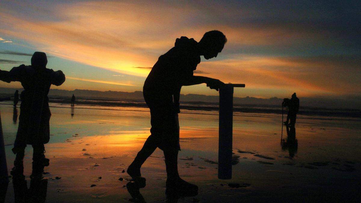A man looks for razor clams on the beach at Ocean Shores shortly after sunset.