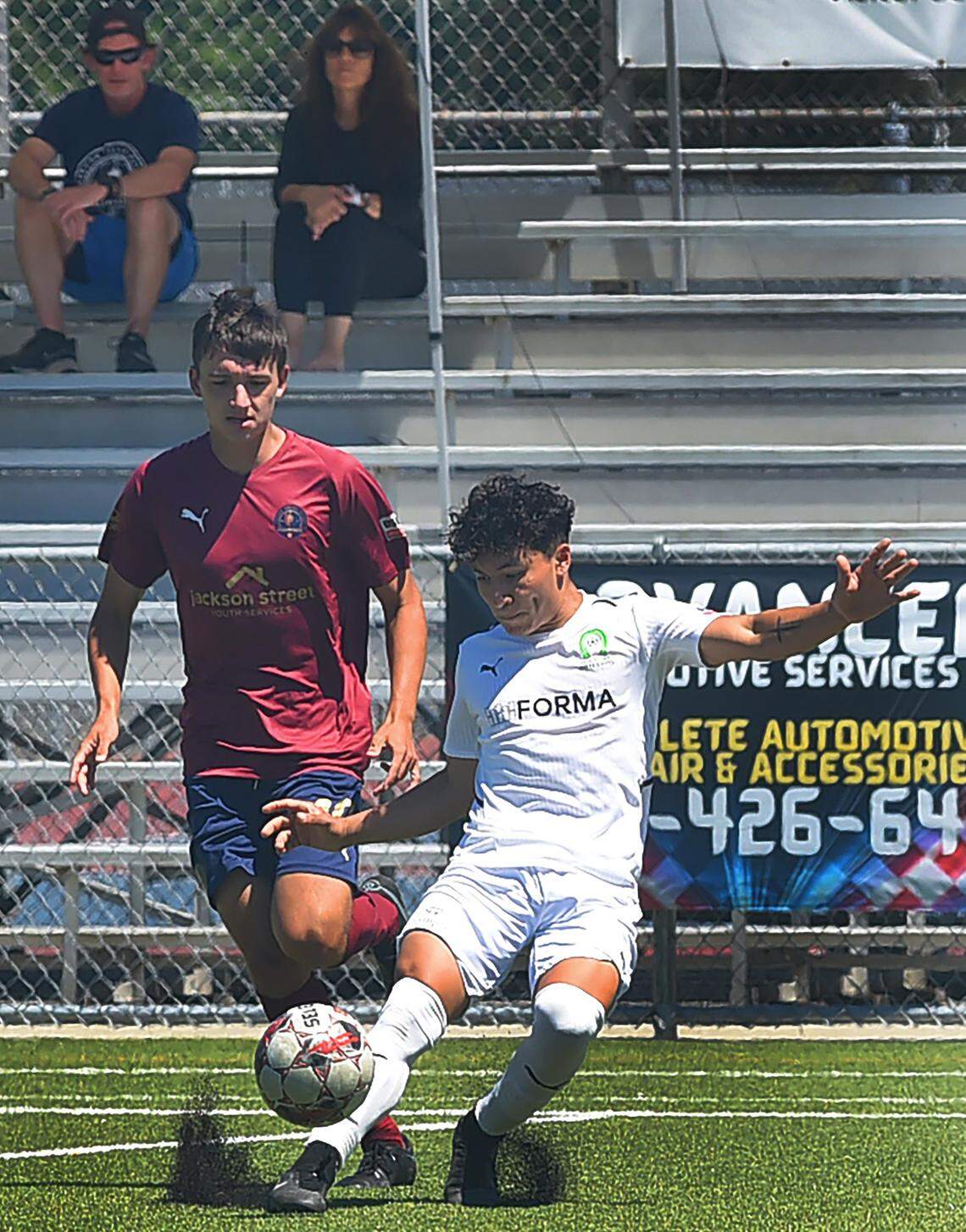 Oly Town Artesians’ defender Manny Nicasio drives the ball away from visiting OFV Alliance midfielder Brendan Herb in the first half of Sunday’s game, and won by Oly Town FC, 6-5.