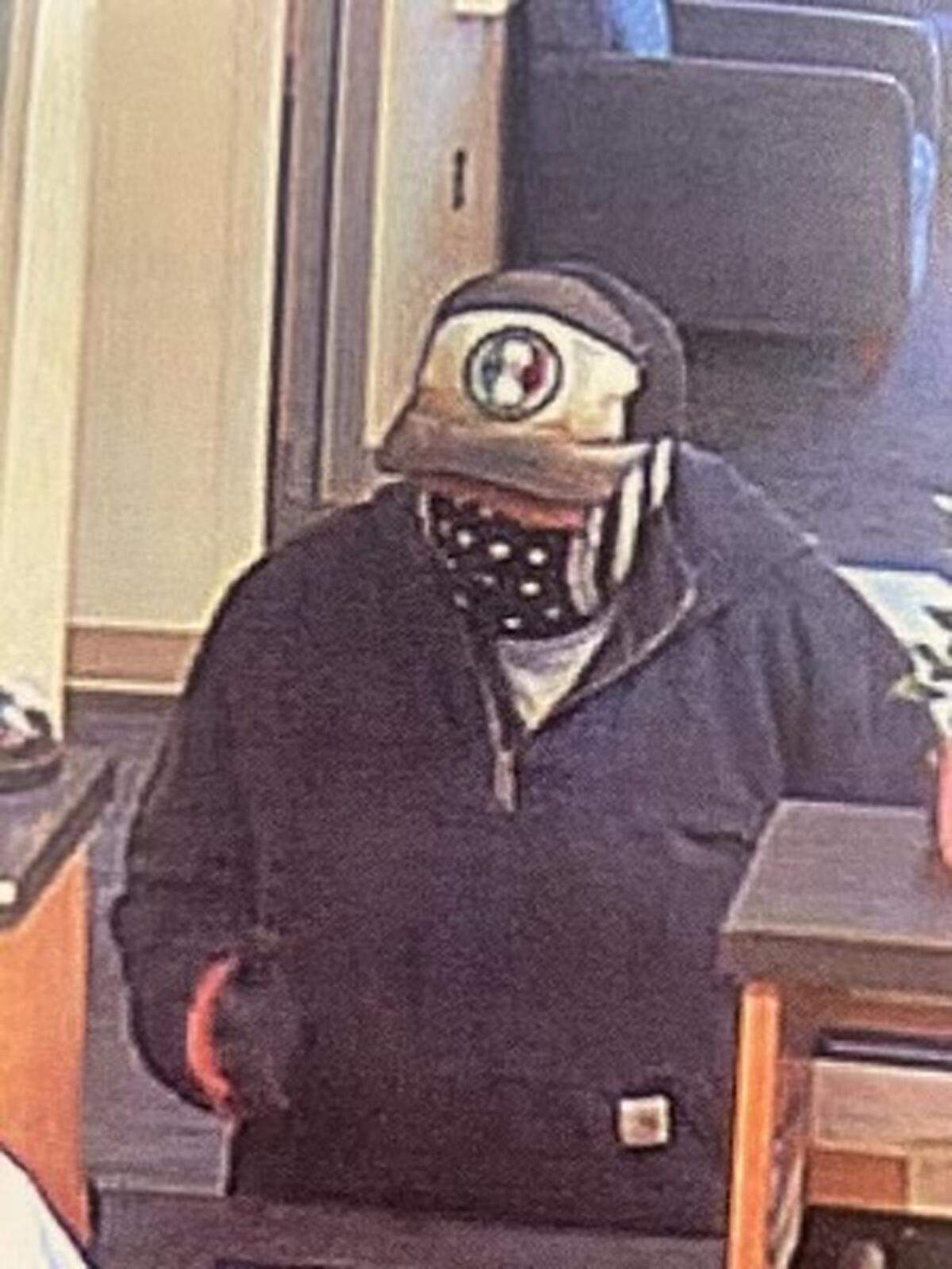 The suspect, implying that he had a weapon, robbed a Heritage Bank branch on Trosper Road, according to Tumwater police. He is still at large.