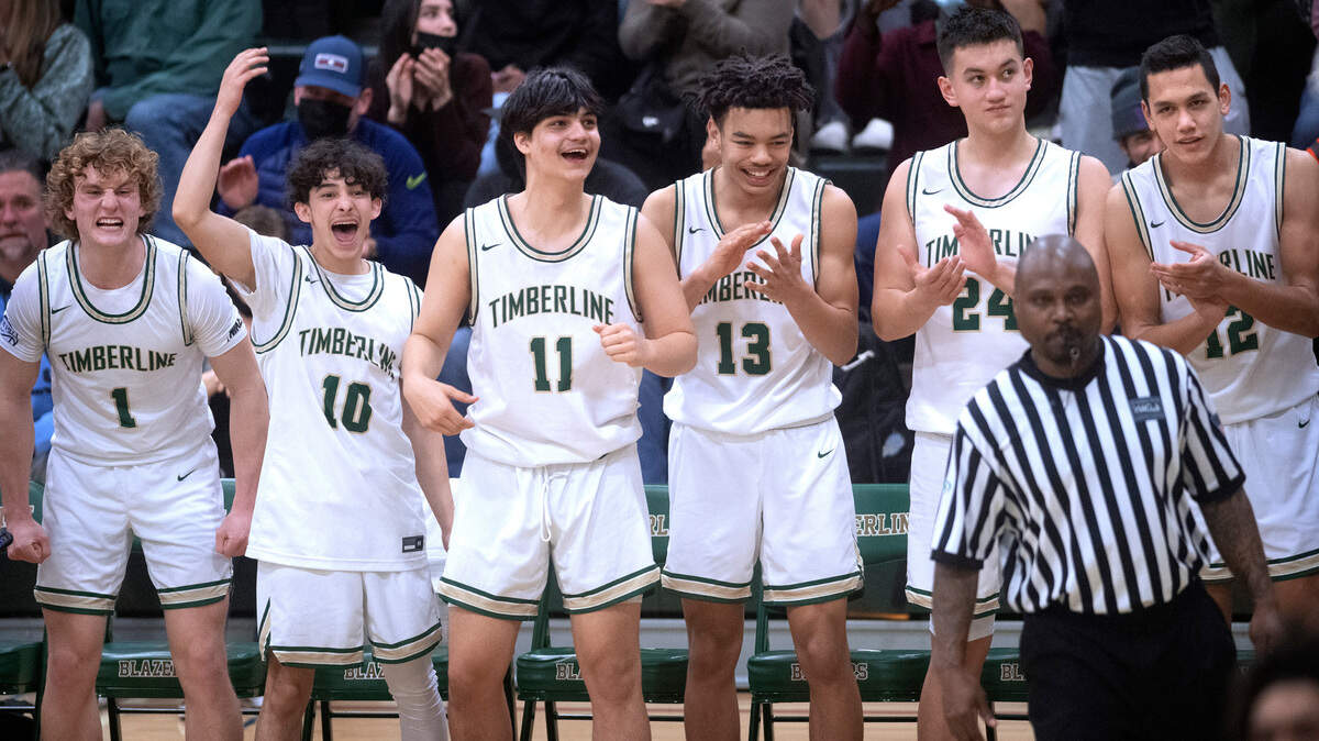 The Timberline Blazer bench (from left) Jackson Brown, Eli Monteagudo-Rodriguez, Ahren Bee-Richards, Kenyon Simmons, Ethan Cornwell and Gage Pedro celebrate a breakaway dunk during Saturday night’s West Central III/Southwest bidistrict tournament boys basketball opening-round game at Timberline High School in Lacey, Washington, on Feb. 12, 2022. Timberline won the game, 70-40.
