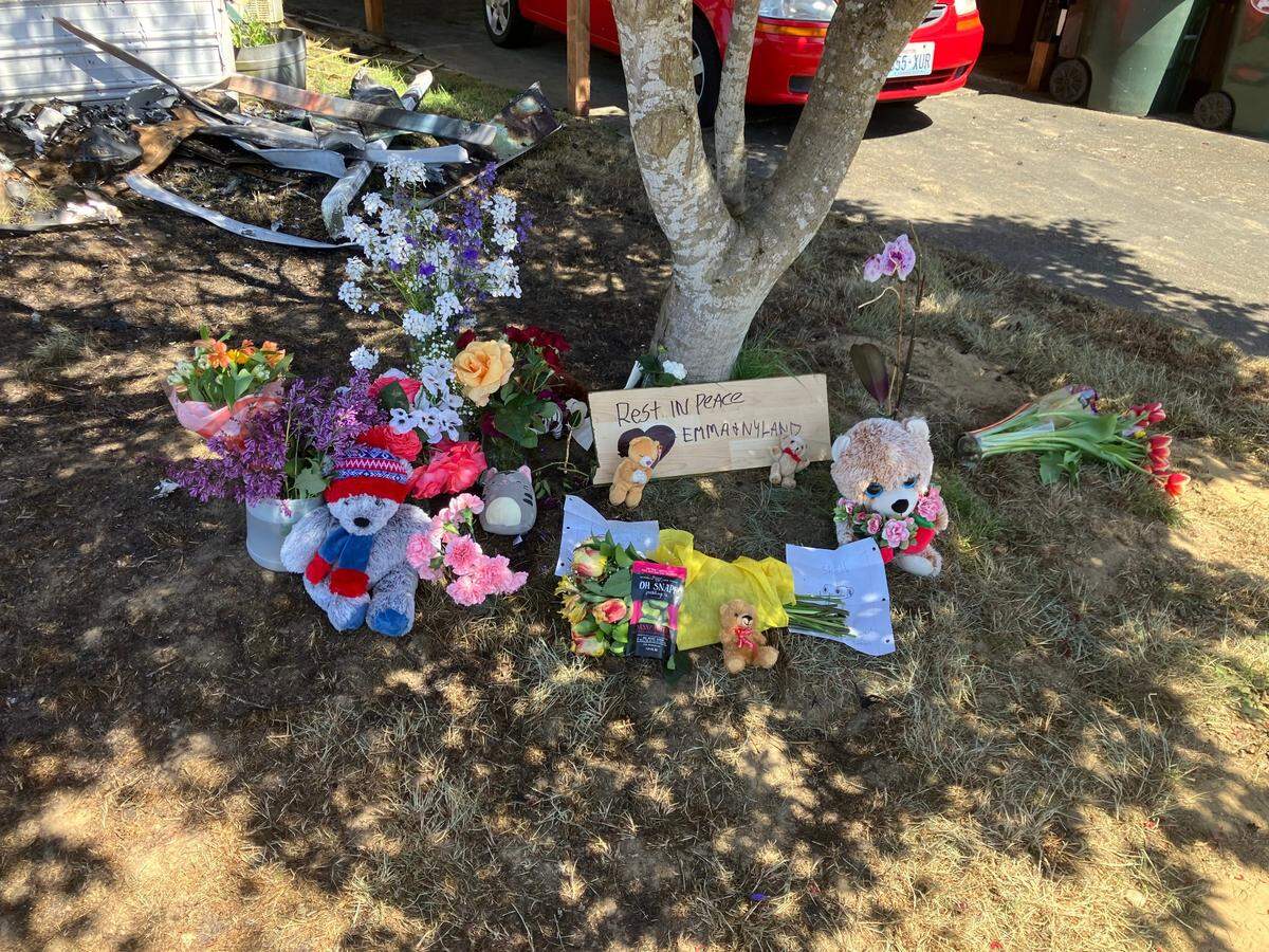 A memorial dedicated to Emma and Nyland, the two children who died in the fire, has sprouted on the burn site.