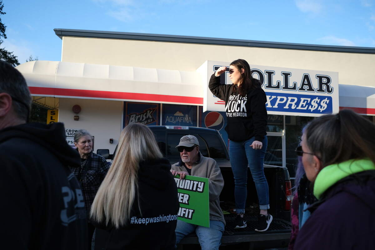 Kerri Jeter, who administers a Facebook group opposed to local sex offender housing, directs a crowd of about three dozen people to protest outside a Supreme Living facility at 6622 Martin Way East near Lacey on Friday, Feb. 10, 2023.