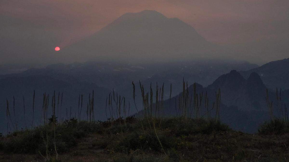 Mount Rainier and the setting sun are shrouded by wildfire smoke Saturday, Sept. 10, as crews from around Washington state battle to contain the Goat Rocks Wilderness fire near Packwood in Lewis County. This photo was taken looking west from Shriner Peak toward Mount Rainier by Bryan Detwiler, a wilderness ranger at Mount Rainier National Park.