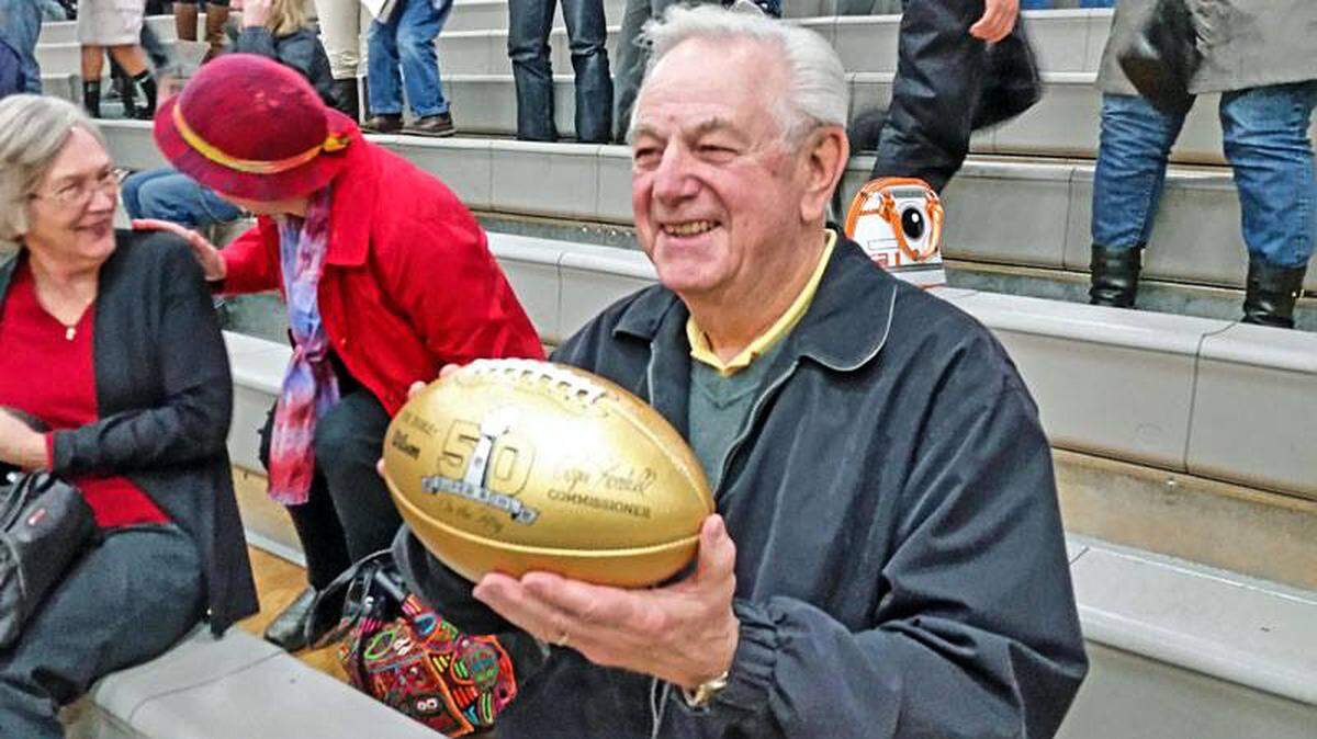 Former Shelton High School football coach Jack Stark holds up a golden football given to him by his former player Raul Allegre, who won two Super Bowls with the New York Giants.