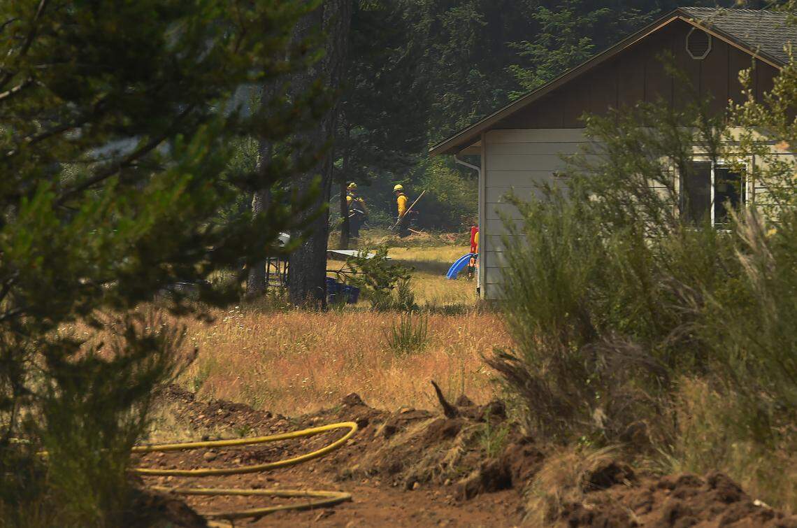 Fire crews snuff out hot spots near a previously threatened home along the E. McEwan Prairie Rd near Shelton, Wa. on Wed. July 5, 2023 All Level 3 evacuation orders in Mason County prompted by the McEwan Fire were downgraded to Level 2 at noon Wednesday, according to the Mason County Sheriff’s Department. The Level 3 orders put in place on Tuesday required people to leave their homes immediately. Under Level 2, residents of the 200 or so affected homes were encouraged to remain away from the area, but they could return if they could remain prepared to evacuate at a moment’s notice.