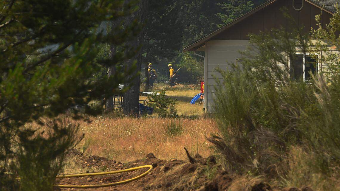 Fire crews snuff out hot spots near a previously threatened home along the E. McEwan Prairie Rd near Shelton, Wa. on Wed. July 5, 2023 All Level 3 evacuation orders in Mason County prompted by the McEwan Fire were downgraded to Level 2 at noon Wednesday, according to the Mason County Sheriff’s Department. The Level 3 orders put in place on Tuesday required people to leave their homes immediately. Under Level 2, residents of the 200 or so affected homes were encouraged to remain away from the area, but they could return if they could remain prepared to evacuate at a moment’s notice.