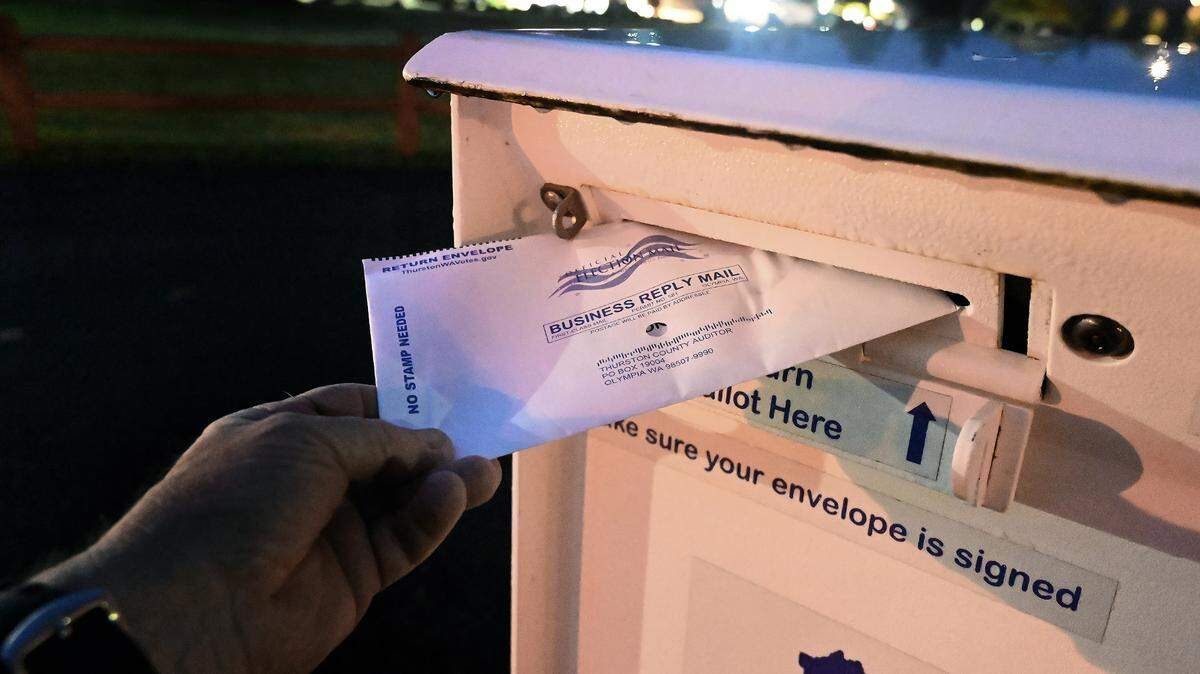 A voter drops off a general election ballot at one of Thurston County’s drop boxes.
