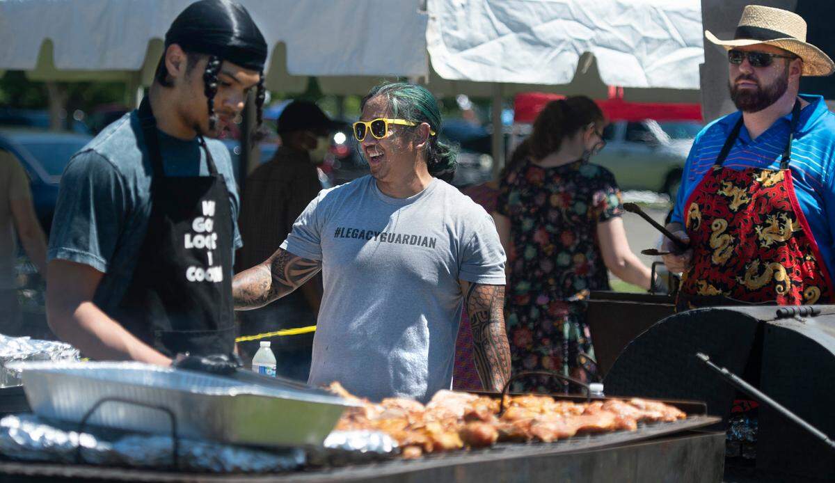 Nixon Sarol (center) of Puyallup works with fellow cooks Mason Wright (left) of Lacey and Derek Lathrop of Tenino as they prepare chicken, spare ribs and tri-tip steak during the Harris Masonic Lodge’s 2021 Juneteenth celebration at the Regional Athletic Complex in Lacey.