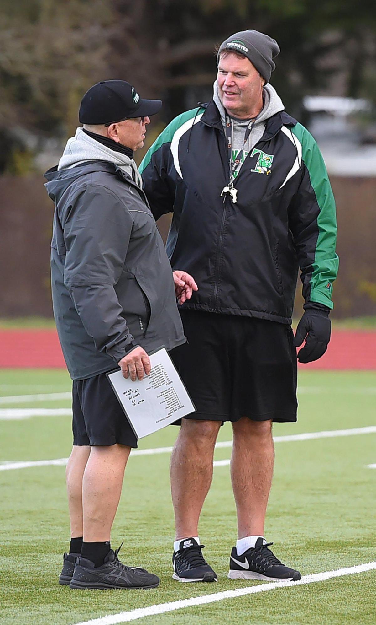 Tumwater football assistant coach Jamie Weeks (left) chats with T-BirdsÕ head coach Bill Beattie during their Wednesday practice before SaturdayÕs championship game against Lynden. Weeks is retiring after 3 decades working in the program, and having been a part of all of Tumwater’s state titles during those years.