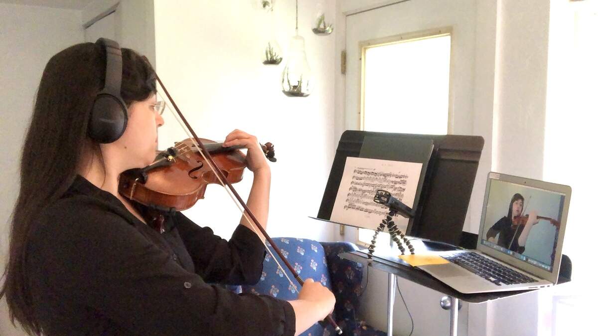 Violinist Katherine Sartori, who teaches orchestra at Washington Middle School and McKenny and Lincoln elementary schools in Olympia, performs at home as part of making a YouTube video of “Pomp and Circumstance.”