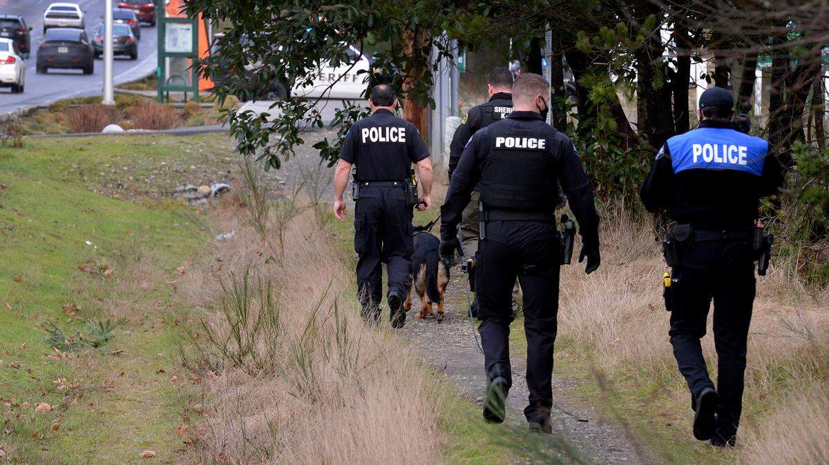 A group of officers including K9 walk along Martin Way and back to Gerald St. in search of a man who reportedly stabbed a woman near a bus stop on Martin Way East. A multi-agency law enforcement response descended on the intersection of Martin Way and Gerald St. around 4 p.m. on Feb 25, 2021.