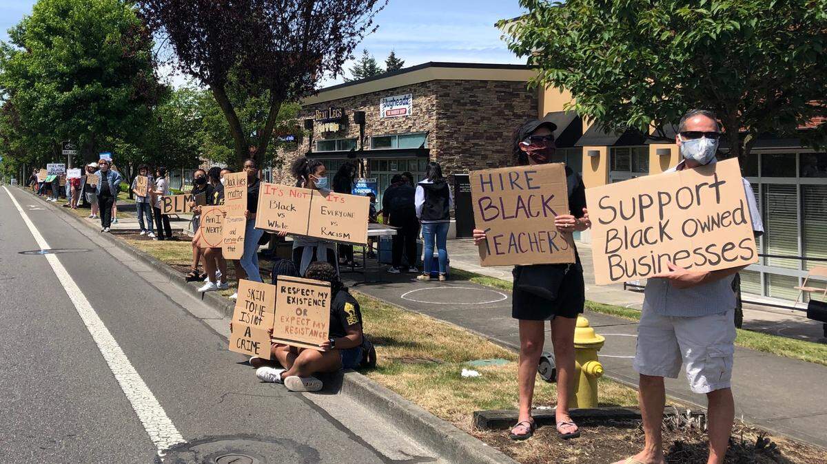 Students, Teacher, Parents and Community members stand outside Beau Legs Fish ‘n’ Chips and Jugheadz barber shop on Martin Way E., waving signs in support of the two local Black owned businesses. Other signs were in support of River Ridge’s Black Student Union’s initiative to bring more Black educators into the school as full time teachers.
