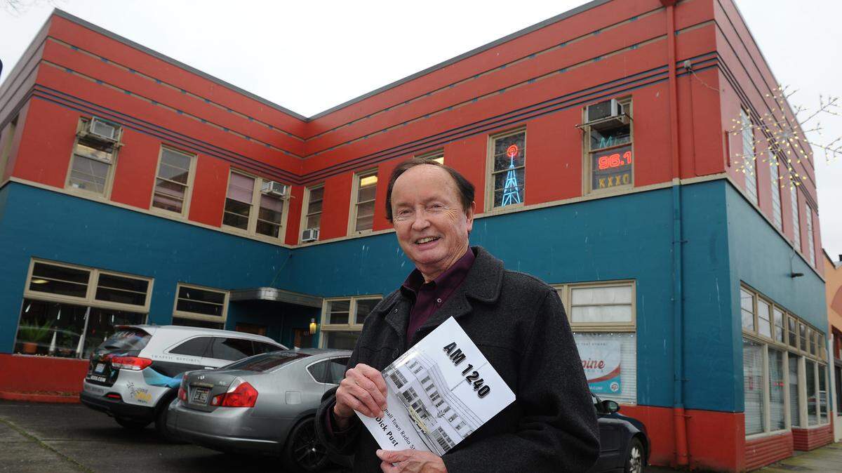 Legendary local radio announcer Dick Pust holds a copy of his new book, “AM 1240 -- Life at a Small Town Radio Station” while standing in front of the Rockway Leland Building in downtown Olympia. Pust currently works part time for KXXO Mixx 96.1 in that building.