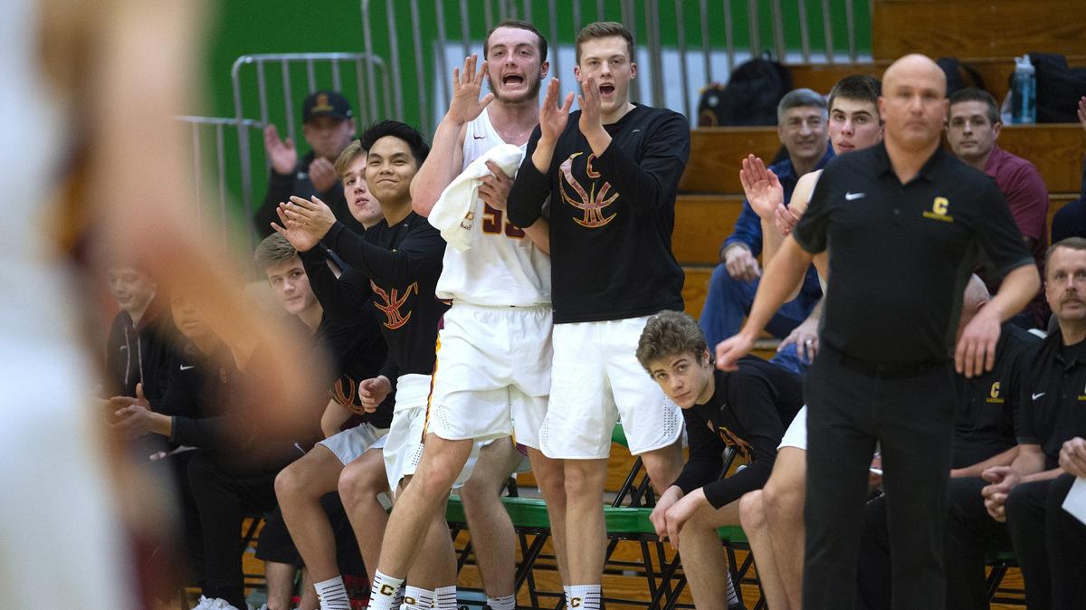 Capital senior Grant Erickson and the Cougar bench celebrate a score during their 3A state regional boys basketball game against Shorecrest at Tumwater High School on Saturday, Feb. 23, 2019.