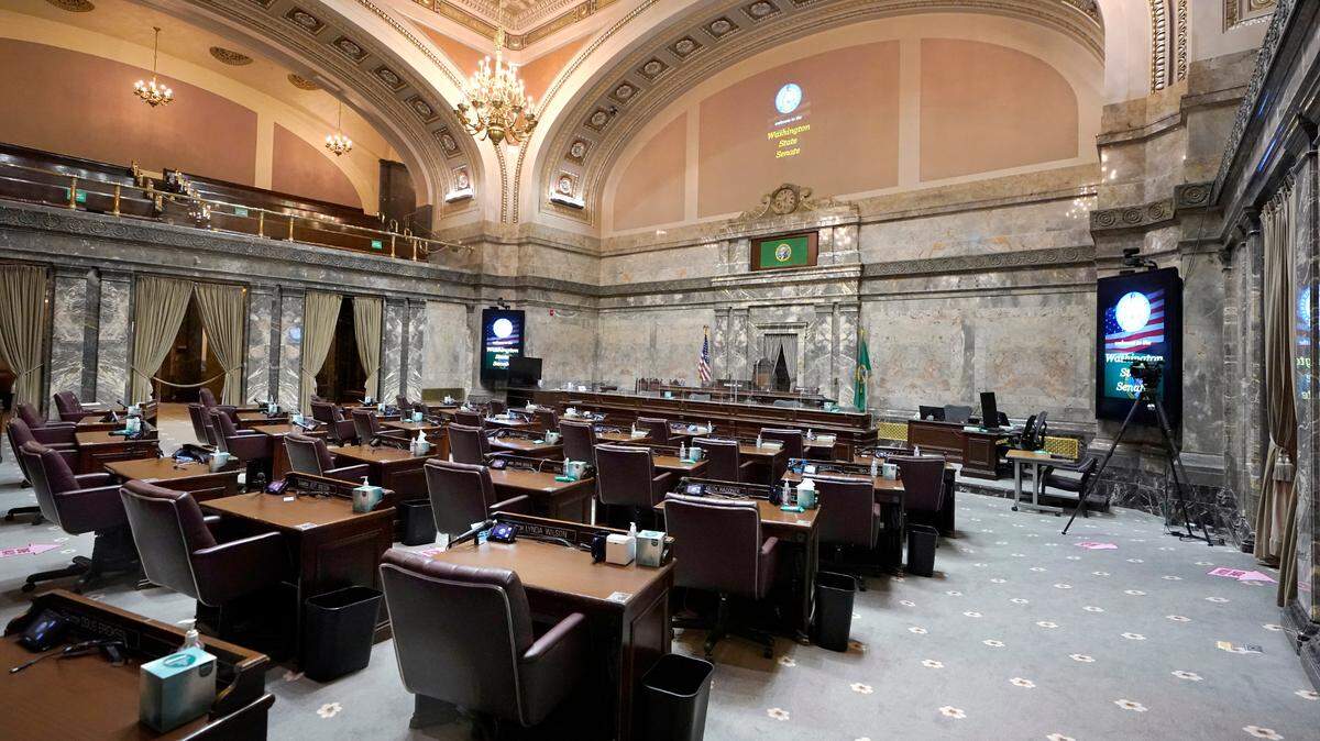 The Senate Chamber sits empty in advance of legislators convening later Monday, Jan. 11, 2021, at the Capitol in Olympia, Wash. Washington state’s Legislature will open under a large security presence because of concerns about efforts by armed groups who might try to disrupt the proceedings or occupy the Capitol, which is closed to the public due to the ongoing pandemic. (AP Photo/Ted S. Warren)