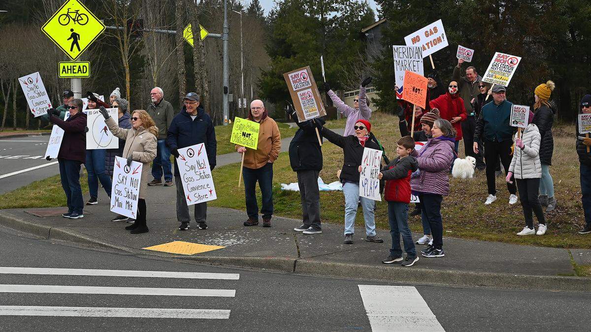 File photo: A group of concerned neighbors gather at the corner of Campus Glen Drive and Willamette Drive in northeast Lacey Saturday morning to protest the planned development of a proposed convenience store with gas pumps.