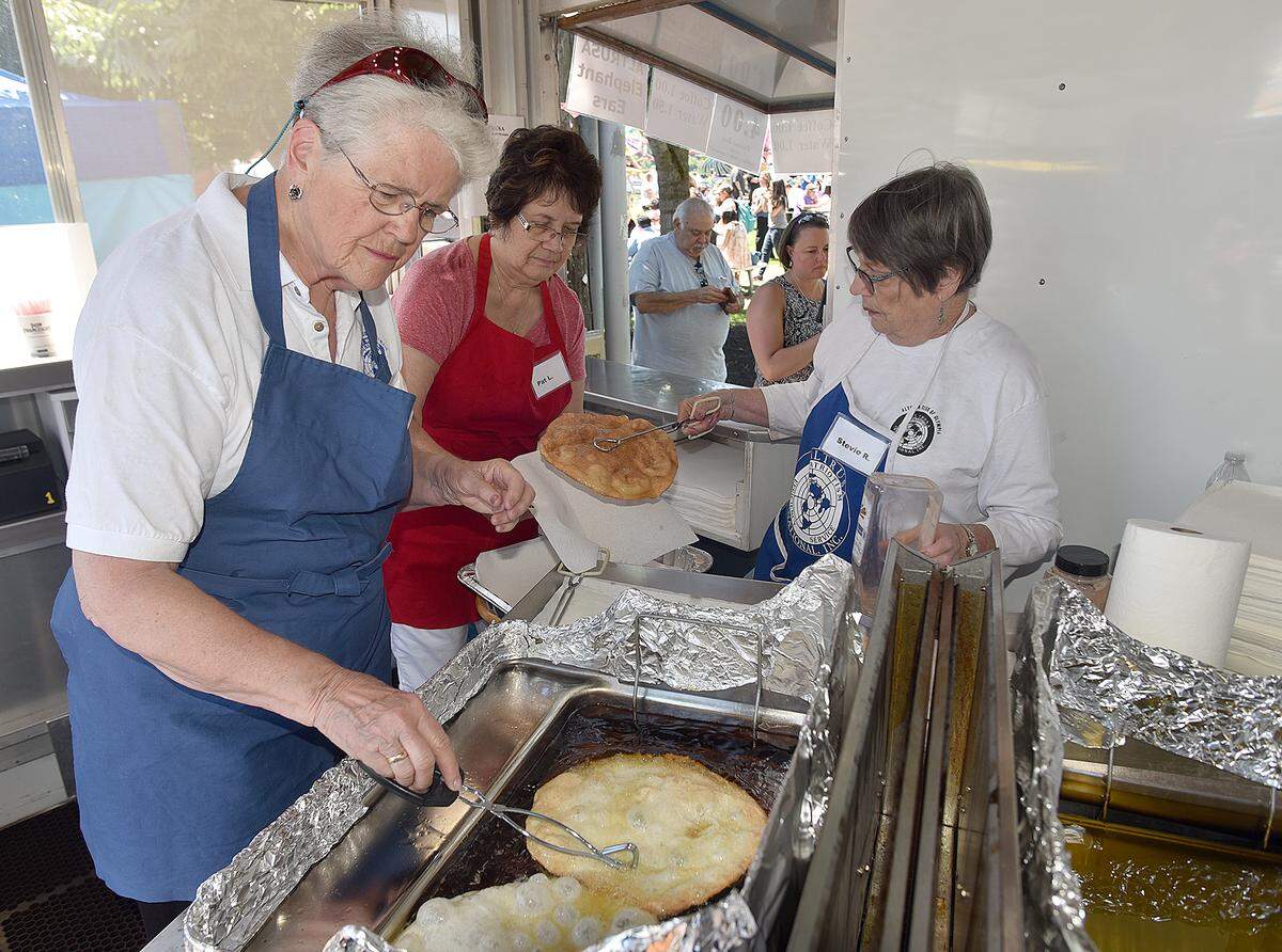 Serving up the ever-popular Elephant Ears are volunteers Karen Stay, Pat Luhr and Stevie Reining, filling another order at the Altrusa food booth on Lakefair’s opening day.