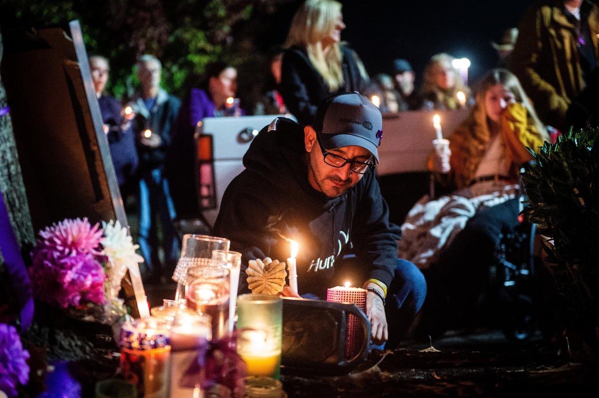 Josh Kendall, a family friend of Maryann McCarty, places his candle at a memorial during a candlelight vigil in memory of McCarty, who was killed in the Michael’s parking lot in Lacey by a former domestic partner. Kendall shared stories about McCarty and described McCarty as “a wonderful friend, great woman, and a great mom.”