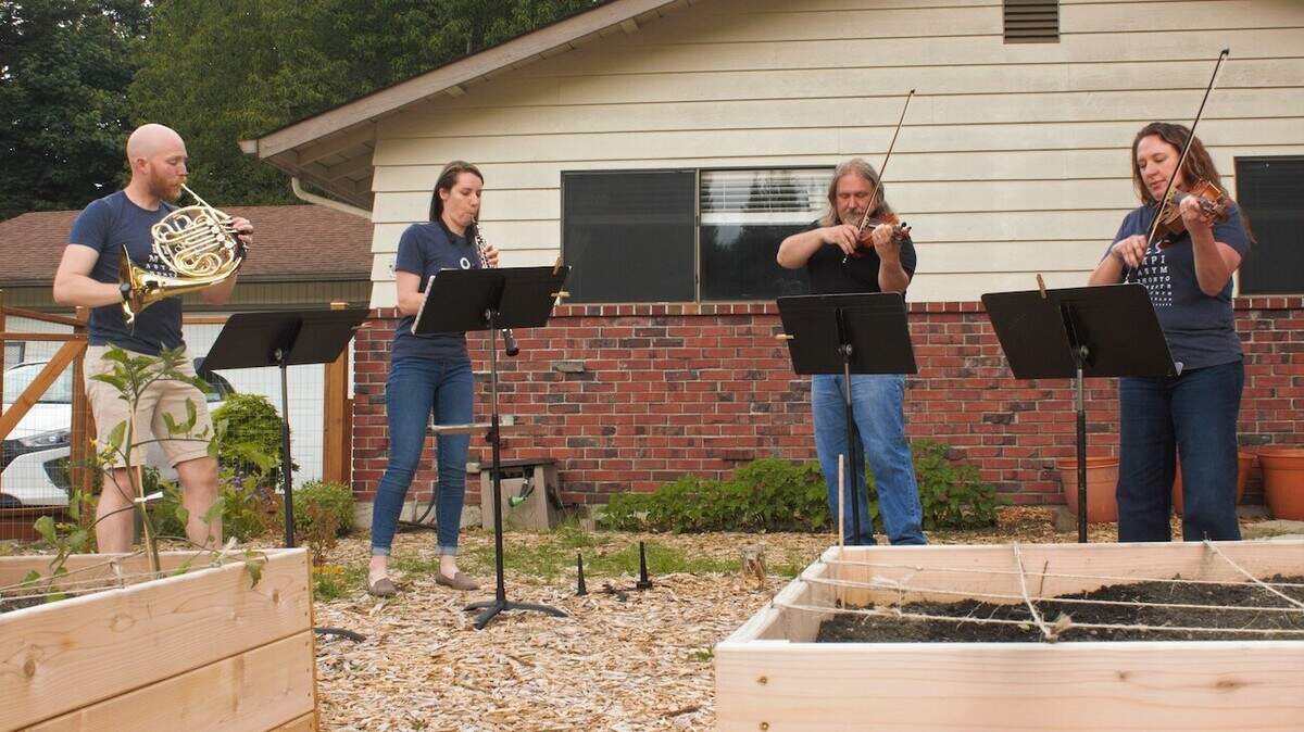 From left are French horn player James Harper, oboist Laura Goben Harper and violinists Brent and Lisa Pearson. The two couples got together to play in the Harpers’ yard in preparation for ensemble performances later this month.