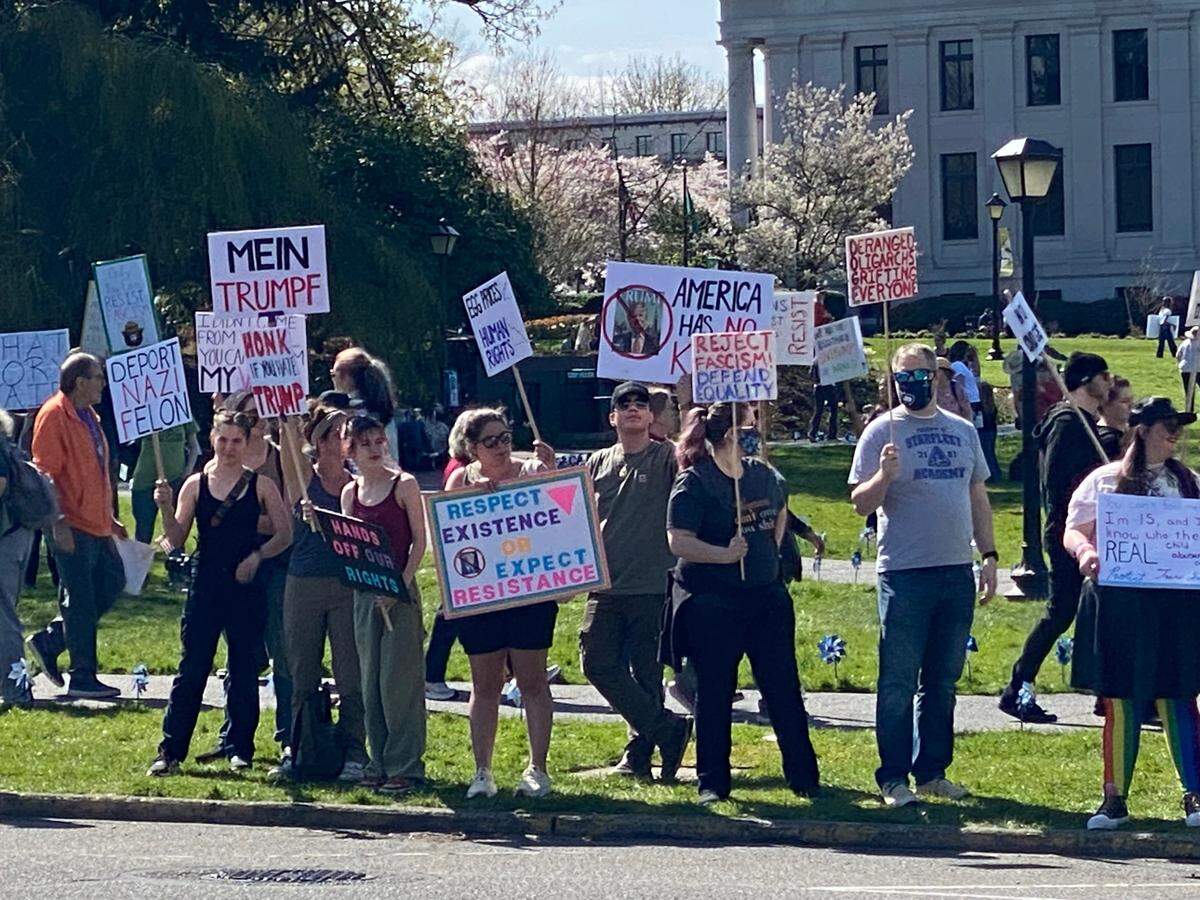 Many protesters attending Saturday’s Hands Off rally lined Capitol Way to chant and wave at passing cars.