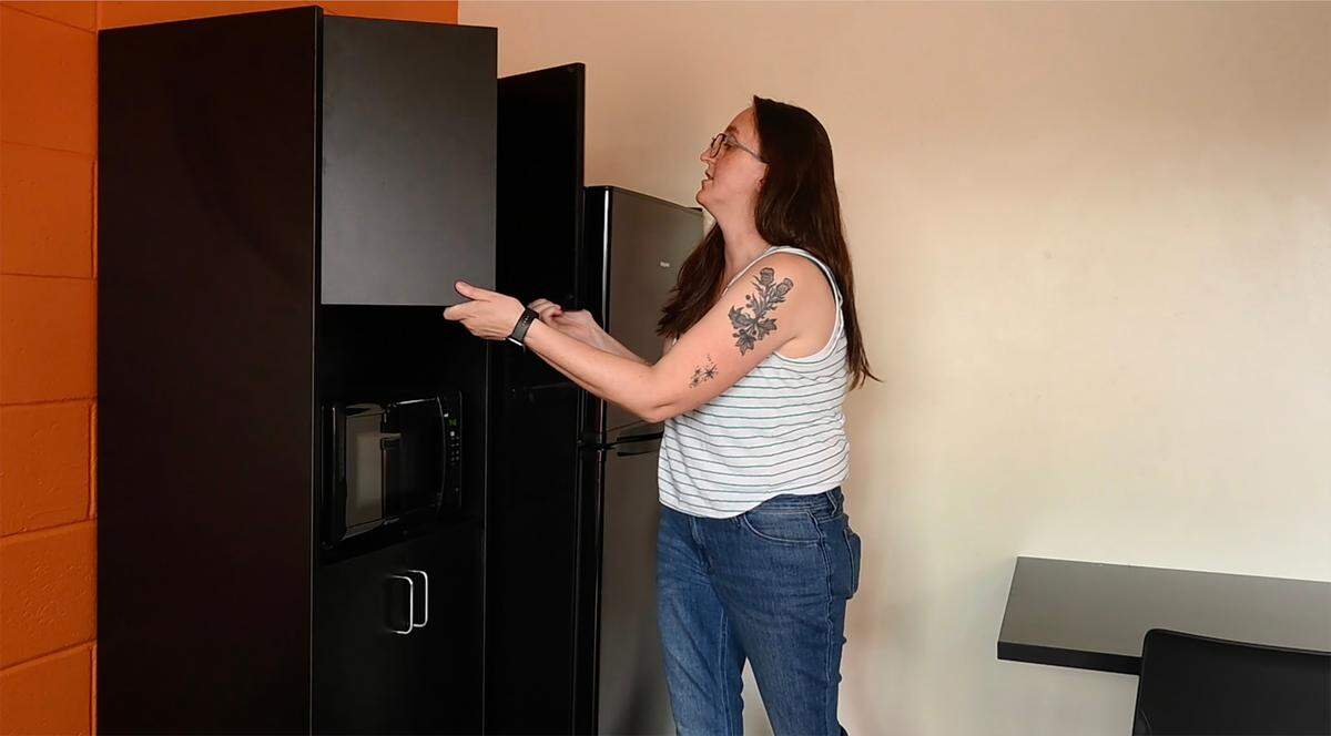 Ivy Ayers points out some of the furnishings offered in each room during a Sept. 6 tour of Sandy’s Flats, a low-income housing project located at the former Olympia Inn location on Capitol Way S. in Olympia,Wa. Operated by the Interfaith Works organization the revived apartment complex offers housing for both individuals and families. The name “Sandy’s Flats” honors Sandy Betz, a former housing guest who was well recognized in and around the Olympia community