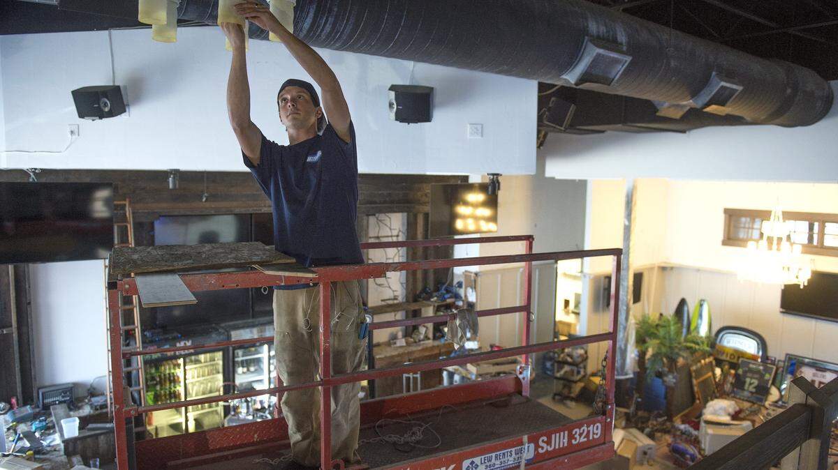 Johnathon Smith, an electrician from Olympia, works on lighting during the renovation of the Pints & Quarts restaurant and sports bar at the Capital Mall in west Olympia in 2015. The restaurant has closed.