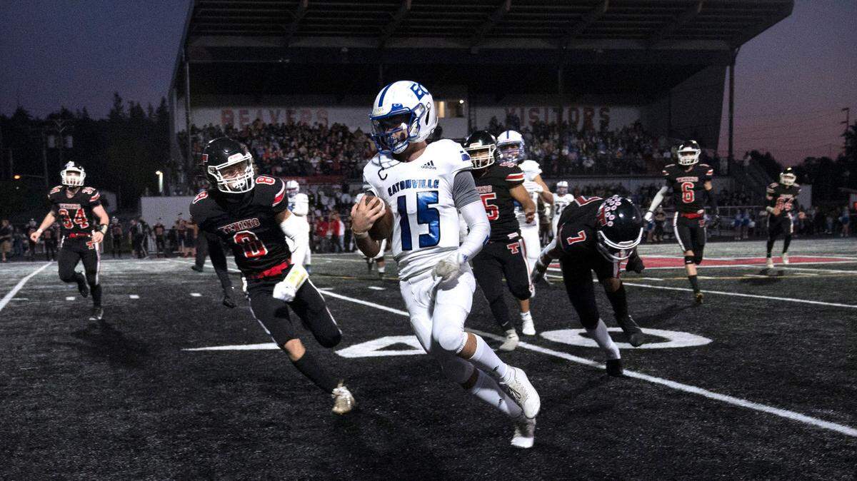 Eatonville quarterback Job Kralik turns the corner in front of Tenino defensive back Keegan O’Connor during Friday night’s 2A football game at Tenino Beaver Stadium in Tenino, Washington, on Sept. 30, 2022.
