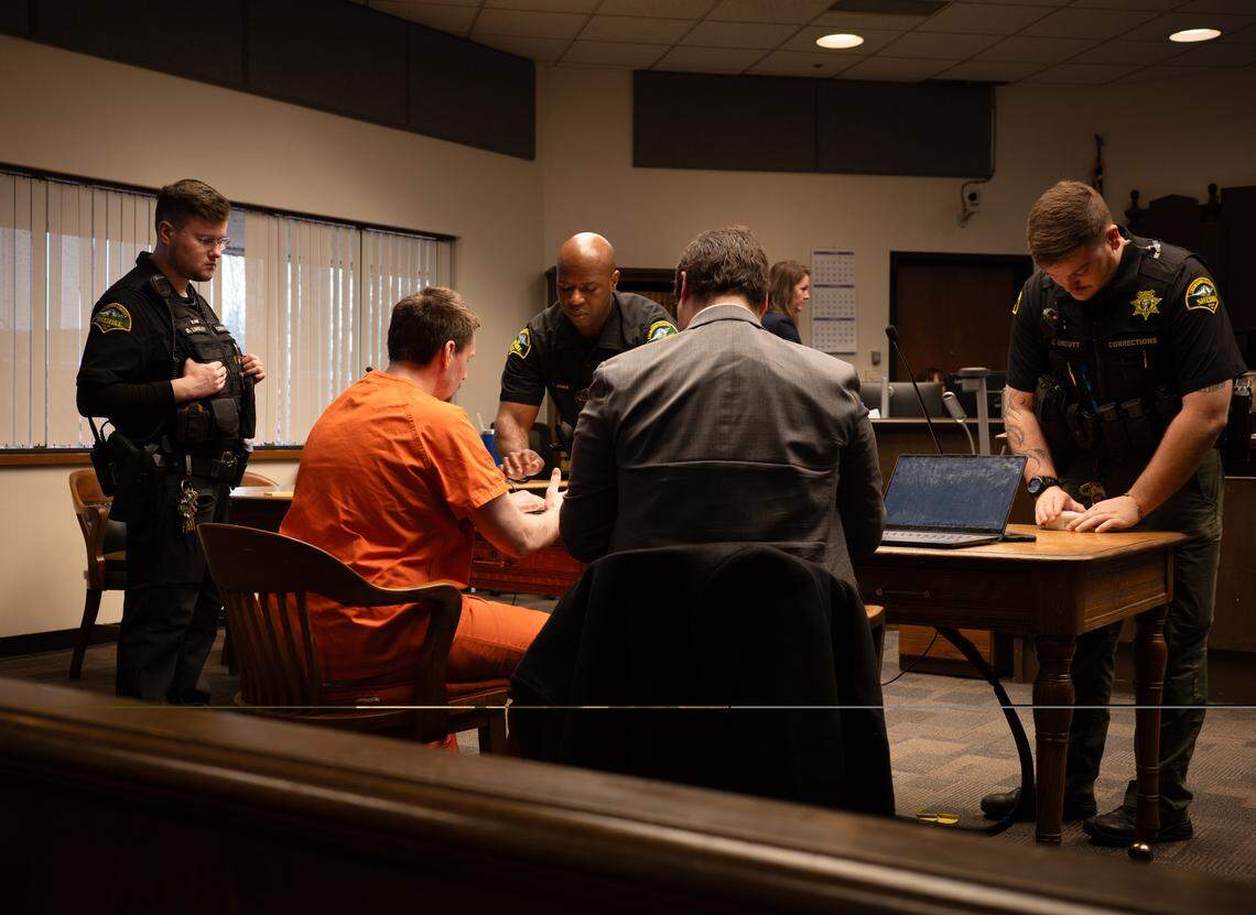 Christopher Edward Snyder, 32, is fingerprinted by Thurston County corrections deputies at the end of his sentencing hearing in Thurston County Superior Court on Wednesday, Nov. 26, 2025. Judge Christopher Lanese ultimately sentenced him to over 55 years in prison in connection to the death of Zebediah Starbrow Schoening, 47.