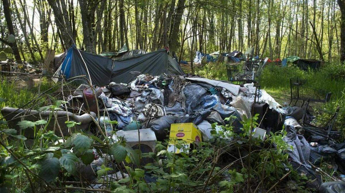Trash piles up in a homeless camp near Martin Way East in Olympia in 2018.