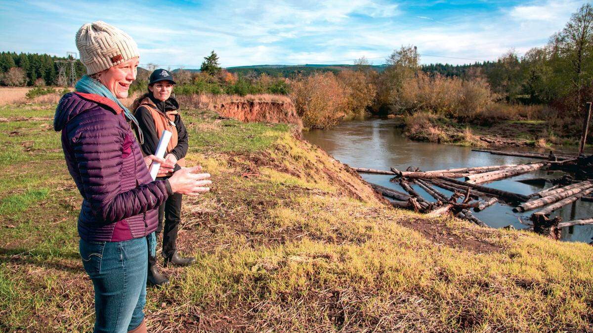 Chehalis Basin Strategy Manager Celina Abercrombie, left, and Mara Healy, a habitat specialist with the Thurston Conservation District, stand near the bank of the Skookumchuck River in Tenino talking about a Chehalis Basin restoration project.