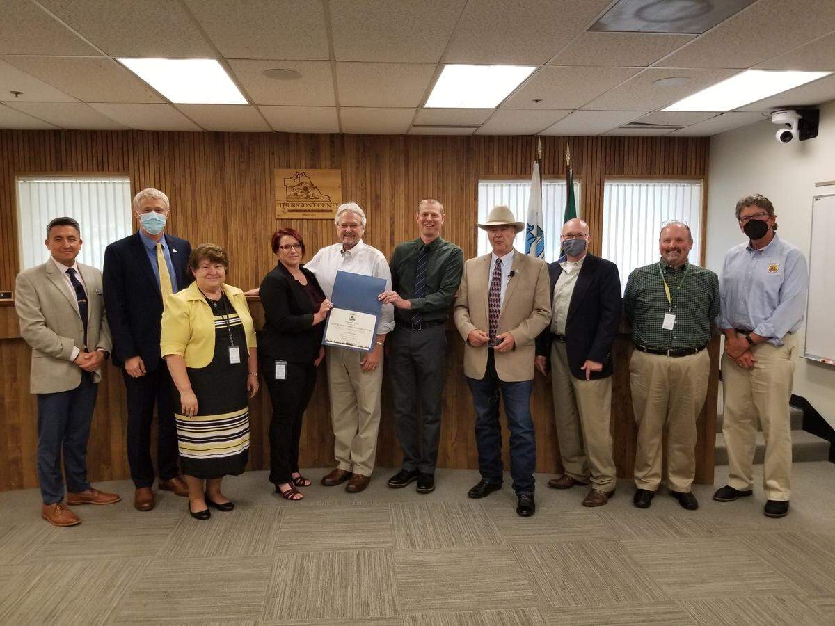 Brad Thompson, state supervisor for the USFWS Washington State Field Office, presents current and former Thurston County officials with a ceremonial 30-year Incidental Take Permit for the county’s Habitat Conservation Plan on Tuesday, July 12, 2022.