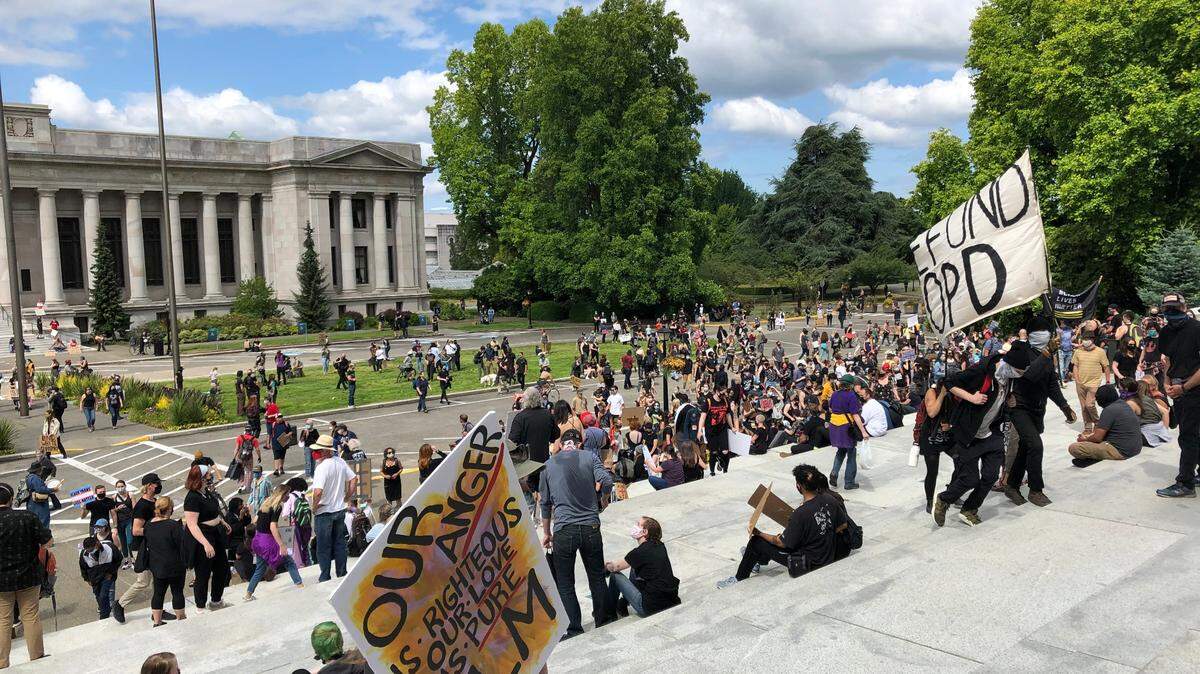 Protester gather on the steps of the Capitol building in Olympia Washington after marching from Woodruff park on the west side. At the Capitol, organizers set up speakers and a microphone for people to share their thoughts on reform.