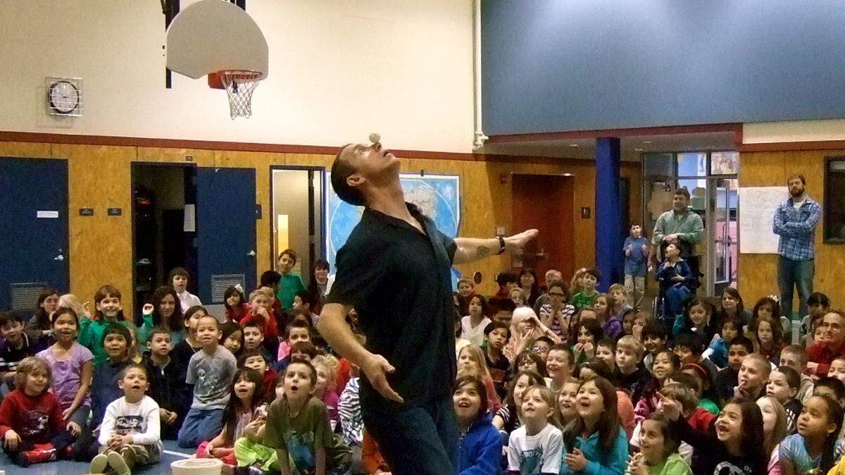 Stuntologist Sam Bartlett balances a ping pong ball on his nose, much to the delight of his audience.