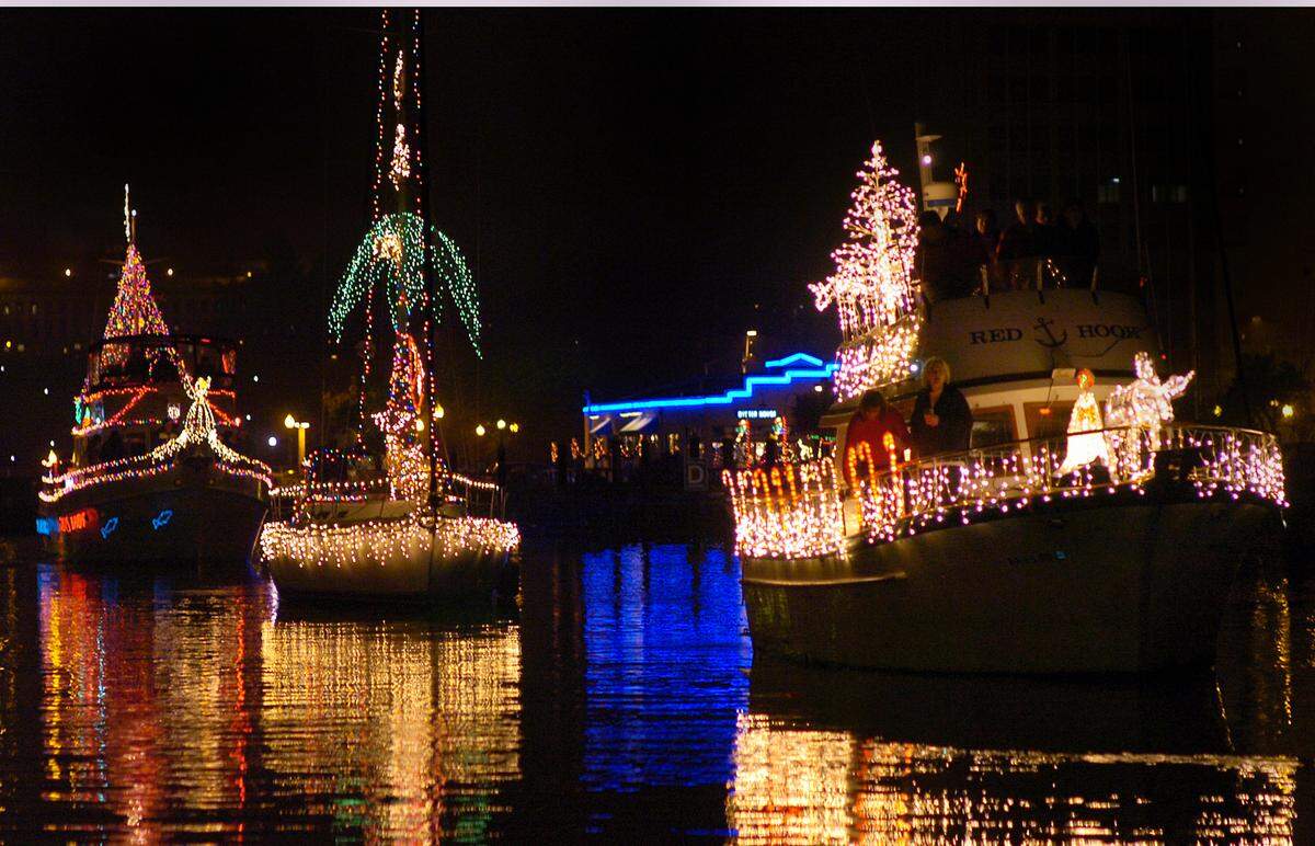 A trio of brightly lit boats depart Percival Landing as part of the 2006 Parade of Lighted Ships