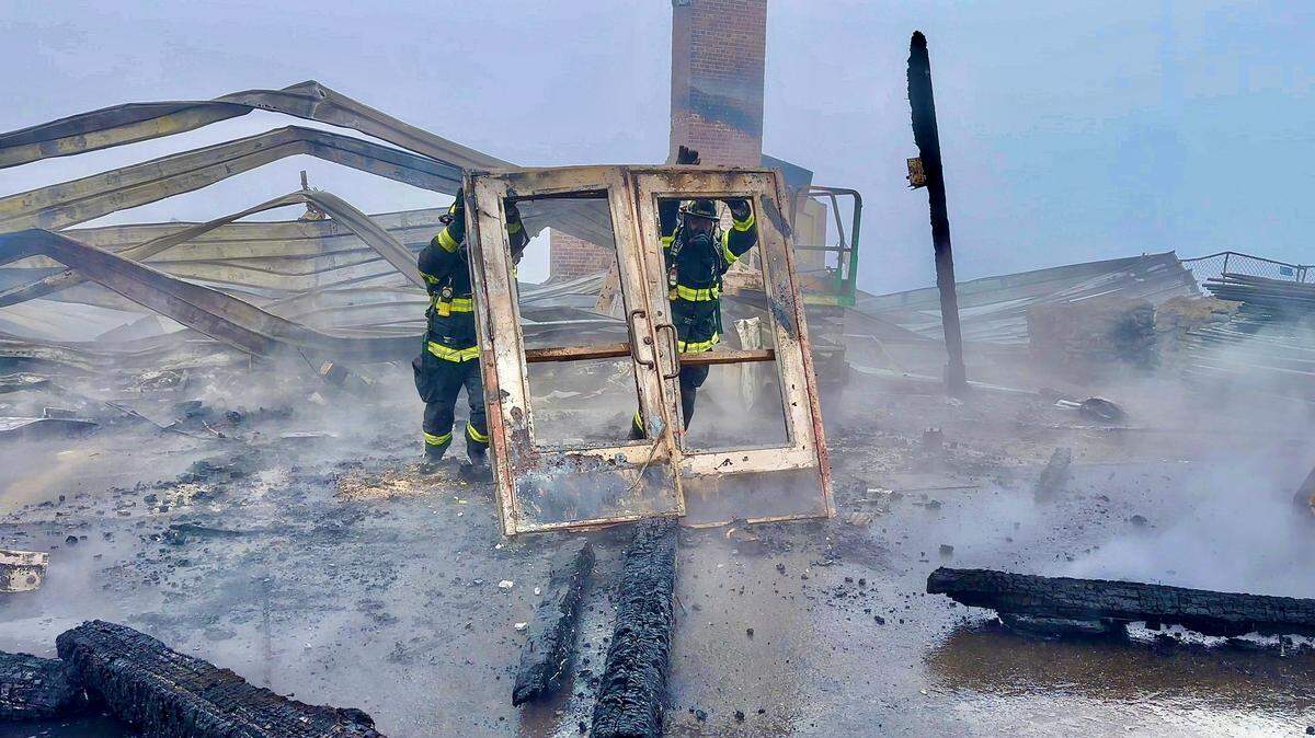 Clallam County Fire District 2 firefighters remove a damage doorway after fire destroyed the Hurricane Ridge day lodge on Sunday, May 7.