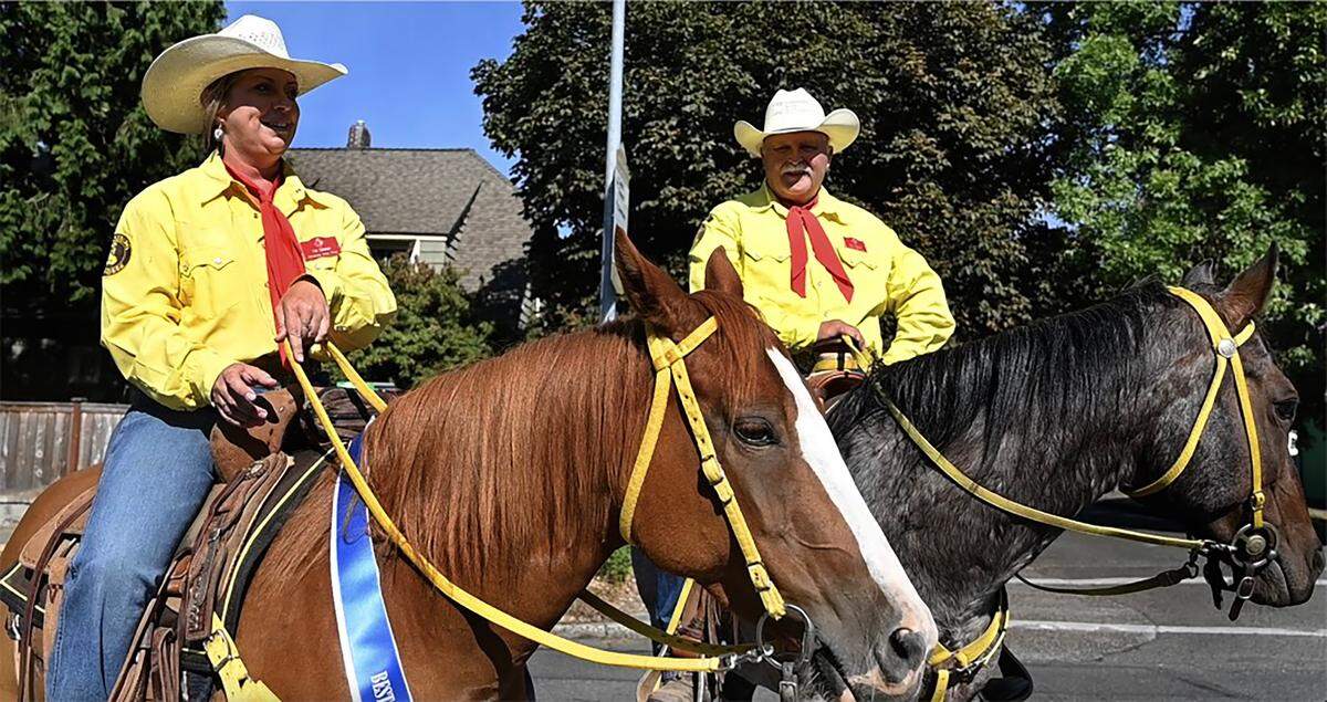Ellensburg Rodeo Posse members Morgan Farrell and posse Capt. Roy Chance along with their parade partners “Midge” and “Belle” get set for the start of the annual 2024 Capital Lakefair Grand Parade on Saturday evening.