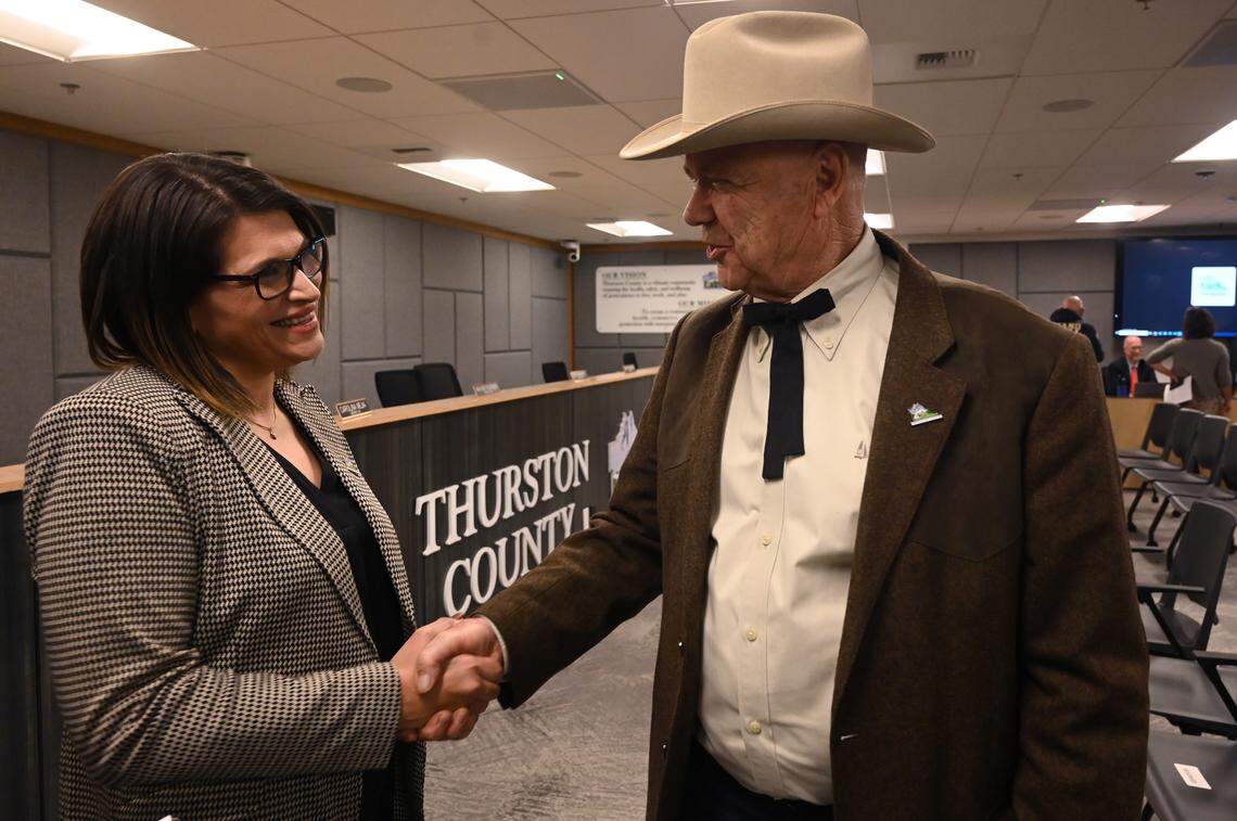 Newly elected Thurston County Commissioner Rachel Grant is congratulated by outgoing Commissioner Gary Edwards after the Dec 17, 2024 swearing in ceremony at the Atrium building in Olympia which houses county services.