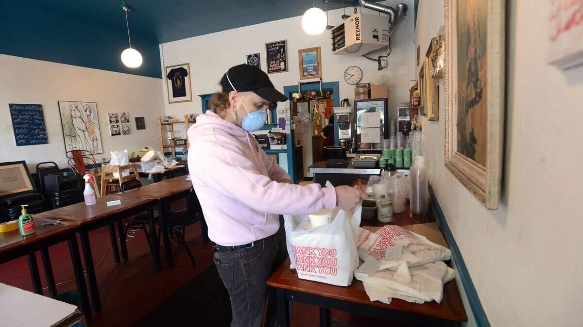 New Moon Cooperative Cafe worker/owner Tanner Hainsworth packs up a Sunday morning order on April 26 as the downtown Olympia restaurant adapts to the COVID-19 closures by offering a pick-up menu for customers.