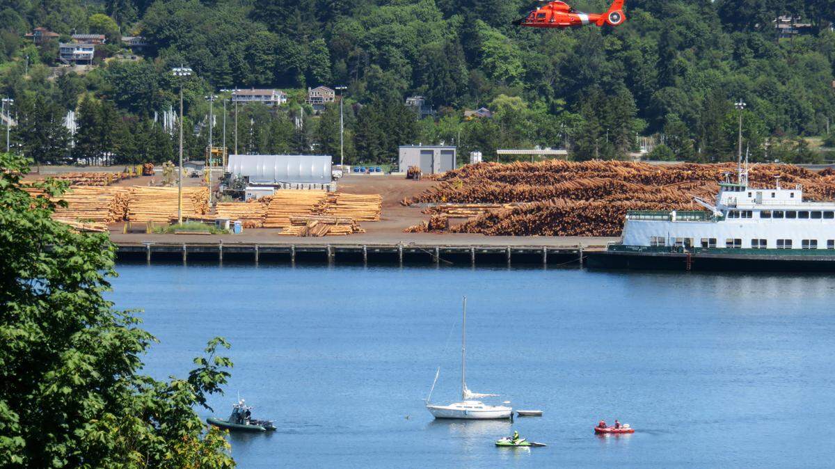 A Coast Guard helicopter searches West Bay July 18.