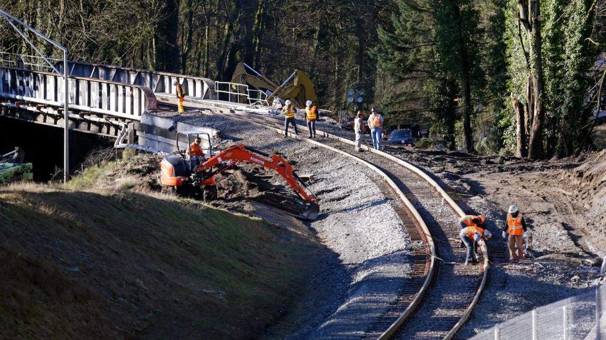 People work at the curve leading to the railroad bridge where an Amtrak train derailed onto Interstate 5 two days earlier Wednesday, Dec. 20, 2017, in DuPont, Wash. The Amtrak train that careened off the overpass south of Seattle, killing at least three people, was hurtling 50 mph over the speed limit when it jumped the track, federal investigators say, when it derailed along a curve, spilling railcars onto the highway below. (AP Photo/Elaine Thompson)