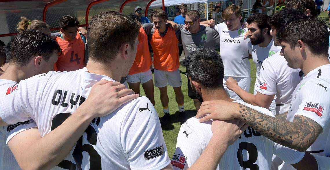 Oly Town Artesian FC head coach Jason Smith (center, grey shirt) fires up the team before taking the field against visiting Oregon Valley Futbol Alliance from Oregon in a USL League Two match at Black Hills High School on June 26,2022
