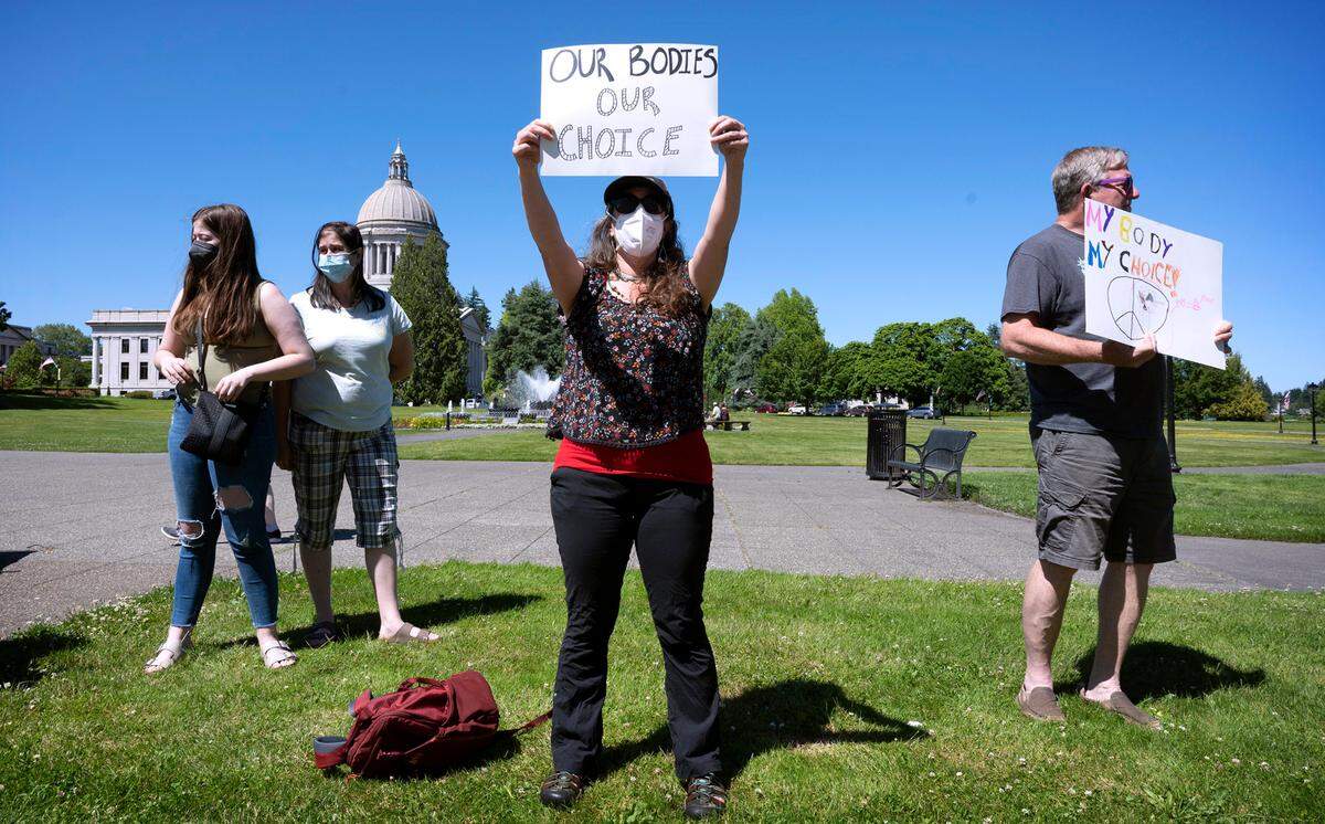Women’s rights supporters (from left) Lacy Nadeau, Carolyn Nadeau, Rebecca Rutzick and Joe Ward, all of Olympia, rally on the Capitol Campus in Olympia, Washington on Friday, June 24, 2022, following the morning’s announcement of the U.S. Supreme Court’s overturning of Roe v Wade.