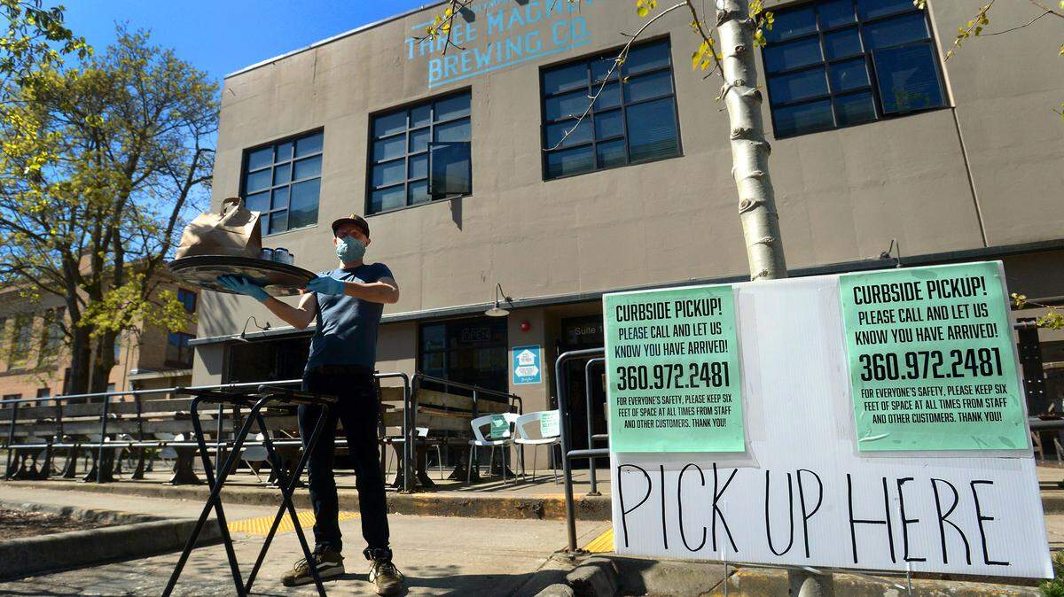 Three Magnets Brewing Co. baker Josh Murphy demonstrates how the downtown Olympia brewpub is serving its customers during the COVID-19 outbreak: a no-contact drive-up delivery service.