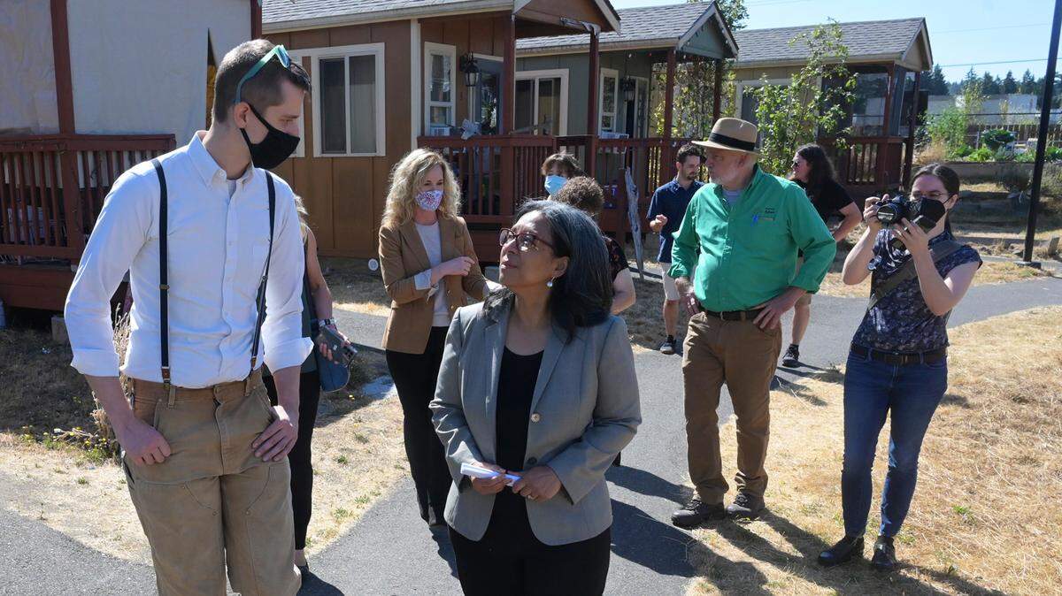 Congresswoman Marilyn Strickland chats with Mason Rolph, president of the Olympia Community Solar organization, during an event marking the starting of a solar installation on at Quixote Village, a 30-unit homeless housing complex in Olympia.