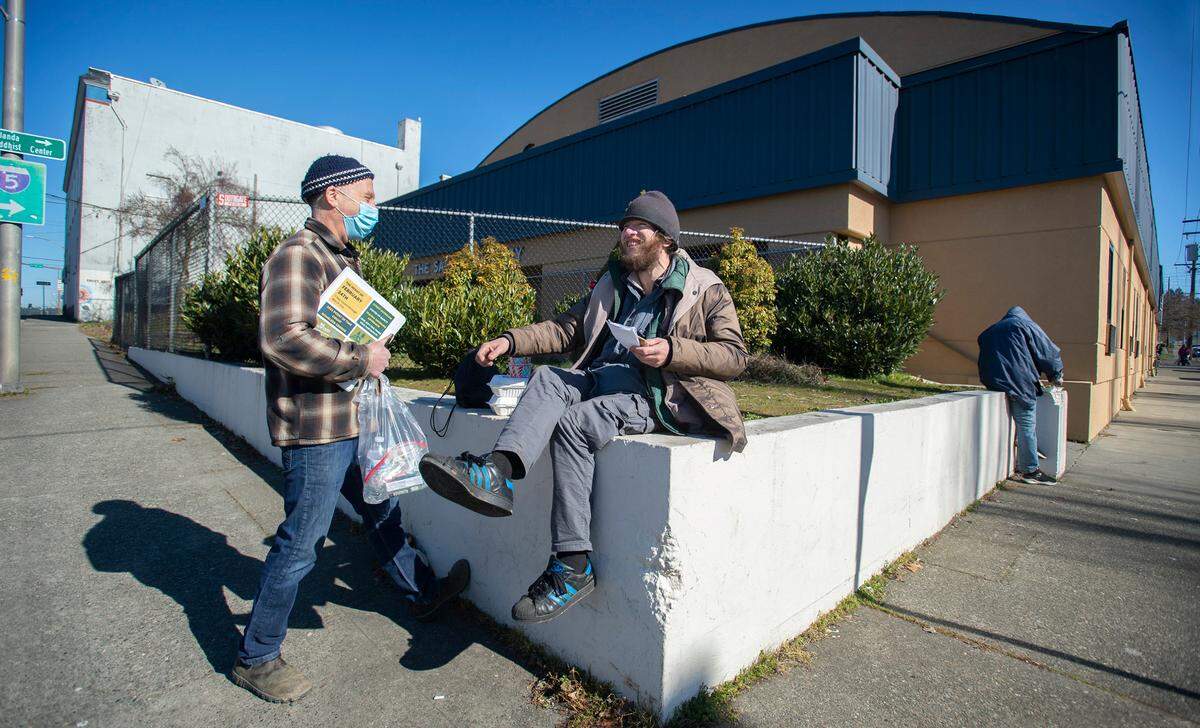 Volunteer Paul Spivak of Olympia talks with Gabriel Withington during the Point in Time homeless census outside the Salvation Army shelter in downtown Olympia on Friday afternoon.